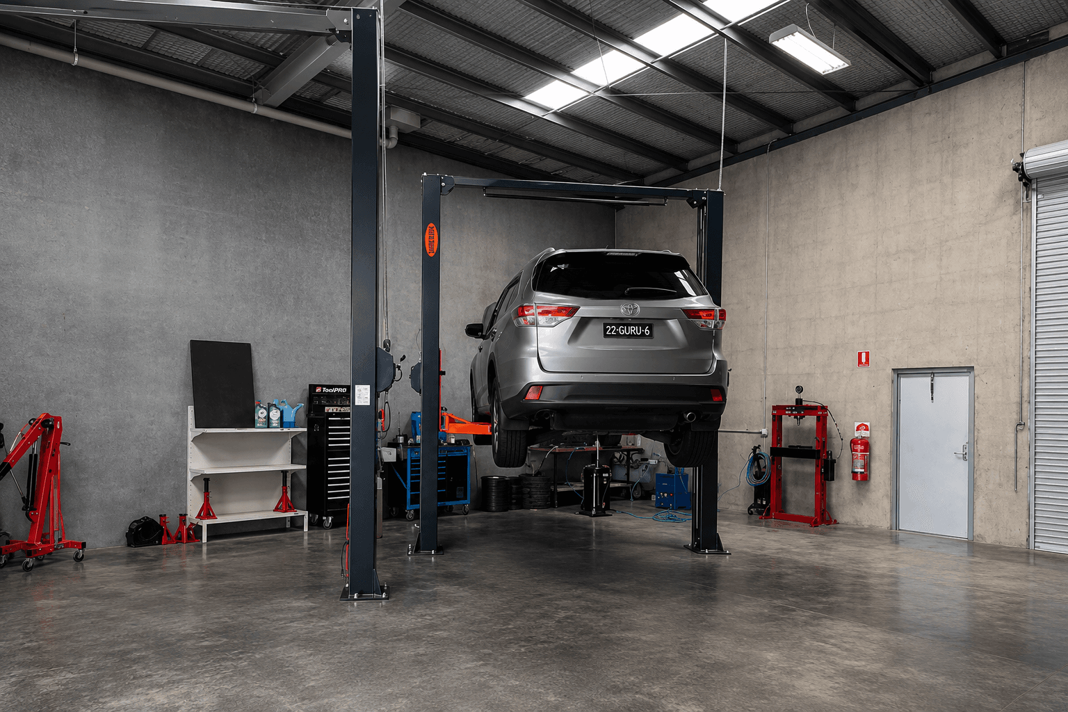 A silver SUV raised on a two-post hoist inside the Grovedale workshop